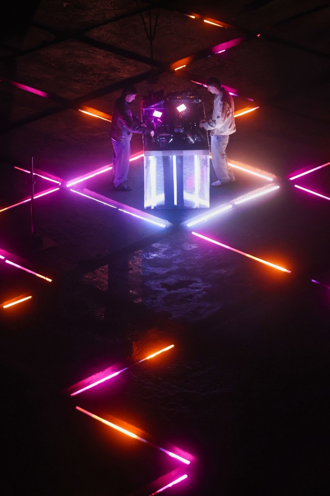 DJ desk with neon pink and orange lights on the ground